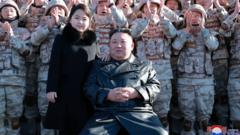 North Korean leader Kim Jong Un and im daughter attend one foto session wit di scientists, engineers, military officials and odas involved in di test-fire of di kontri new Hwasong-17 intercontinental ballistic missile