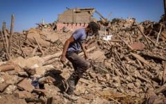 Un homme marche dans les décombres d'un village en ruine