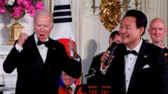 US President Joe Biden reacts as South Korea's President Yoon Suk-yeol sings at an official State Dinner