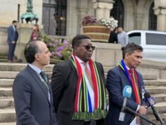 سفير جنوب أفريقيا، فوسيموزي مادونسيلا، لدى هولندا  مع الفريق المشارك في الدعوى أمام محكمة العدل الدولية