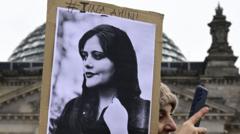 A woman takes a selfie as she holds a portrait of Mahsa Amini during a demonstration in front of the German lower house of parliament on International Women's Day, on 8 March 2023