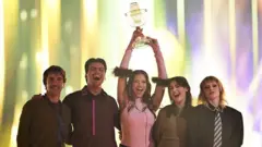 DARA representing Bulgaria with the song 'Bangaranga' and winner of the Eurovision Song Contest, poses for a photo on stage while holding the trophy