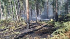 Crews tackling 'fire in the open' near village