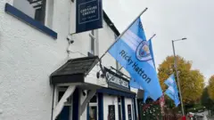 Manchester City flags with Ricky Hatton's name fly outside a pub