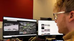 Thomas Copeland who has curly hair, glasses and a beard, is looking at two screens where he's carrying out a reverse image search