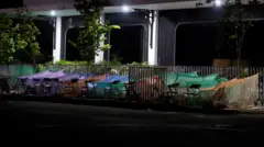 People sleep on a roadside after an earthquake in Nay Pyi Taw under makeshifts tents in purple, orange, blue and green mesh net