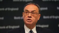 BoE governor Andrew Bailey photographed during press conference, he's in a black suit