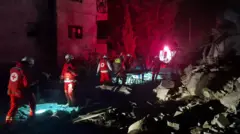Emergency responders walk through rubble