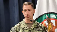 Admiral Brad Cooper speaks in a podium