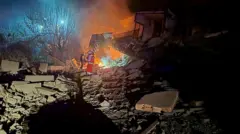 First responders near a building that has been destroyed and turned to rocks and rubble