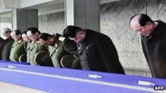 Screen grab from North Korea state television shows Kim Jong-un (in black overcoat) bowing at the memorial service in Pyongyang on 29 December 2011