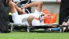 Neil Taylor lies injured on a stretcher