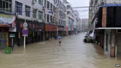 A woman makes her way through a flooded street in disaster-hit Cangnan county of Wenzhou, east China's Zhejiang province, on 7 October 2013