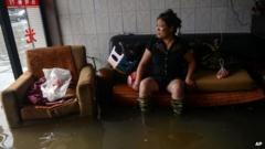 A woman rests as she sits in a flooded building in Cangnan County, east China's Zhejiang Province, 7 October 2013