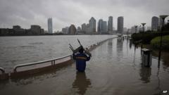 A person carries a chair through a flooded riverside park in Shanghai, China, 7 October 2013