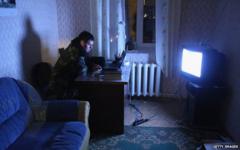 A Ukrainian soldier watches a news broadcast at the Belbek military base in Crimea (4 March)