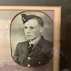 A black and white photo of a young man in uniform in a light gold frame