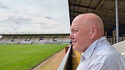David Ince looking out over Cambridge United's empty pitch from the bottom of a stand