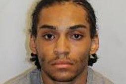 Nathan Otitodilchukwu is seen in a police mugshot wearing a grey sweatshirt, facing the camera against a plain background.