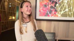 young girl with long blonde hair is smiling as she stands in front of winner photograph entry