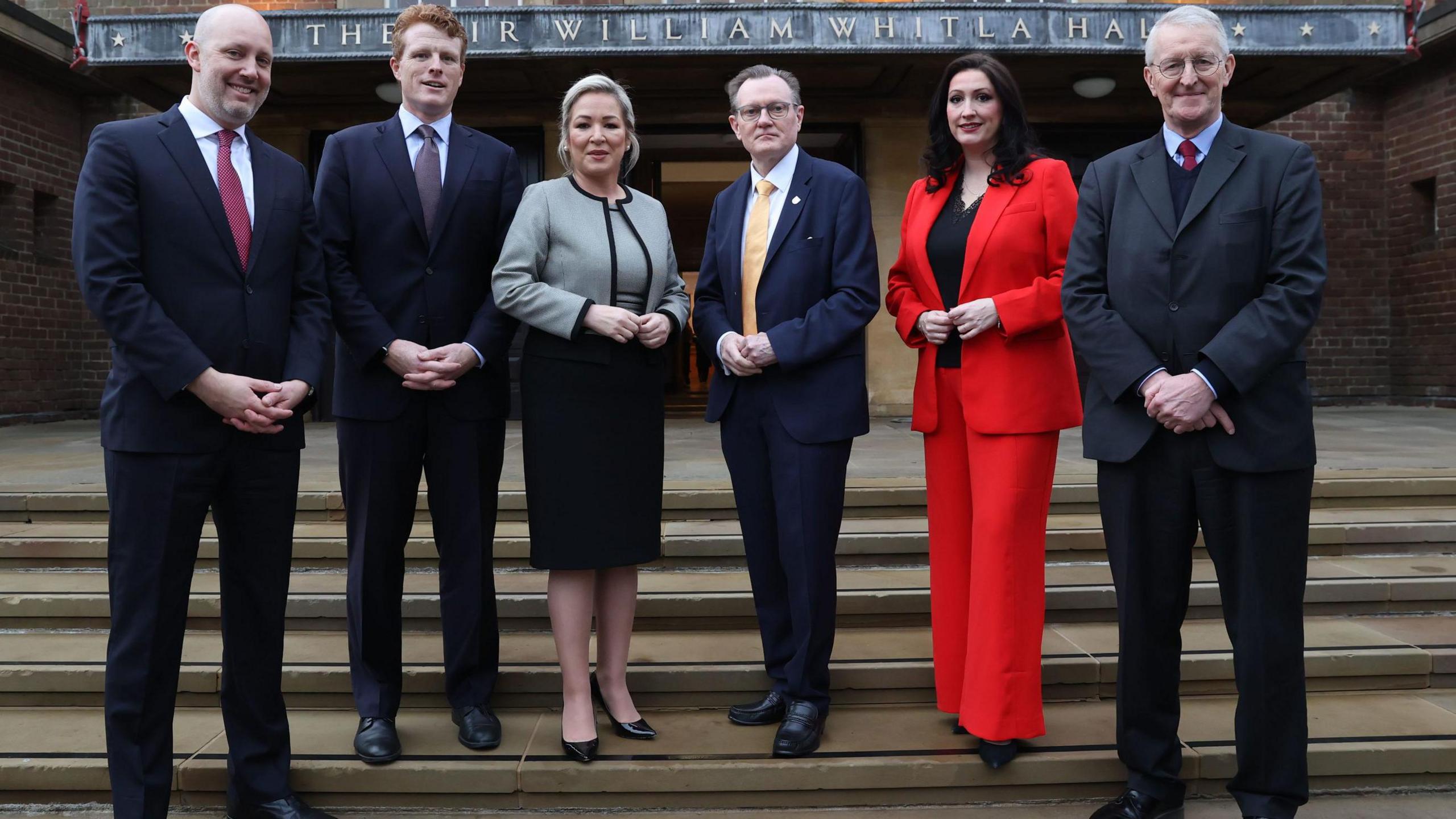 James Applegate, Joe Kennedy, Michelle O'Neill,Professor Sir Ian Greer,deputy Emma Little-Pengelly and Northern Ireland Secretary Hilary Benn, pose for a photograph on day three on the steps of Whitla Hall at Queen's University Belfast.