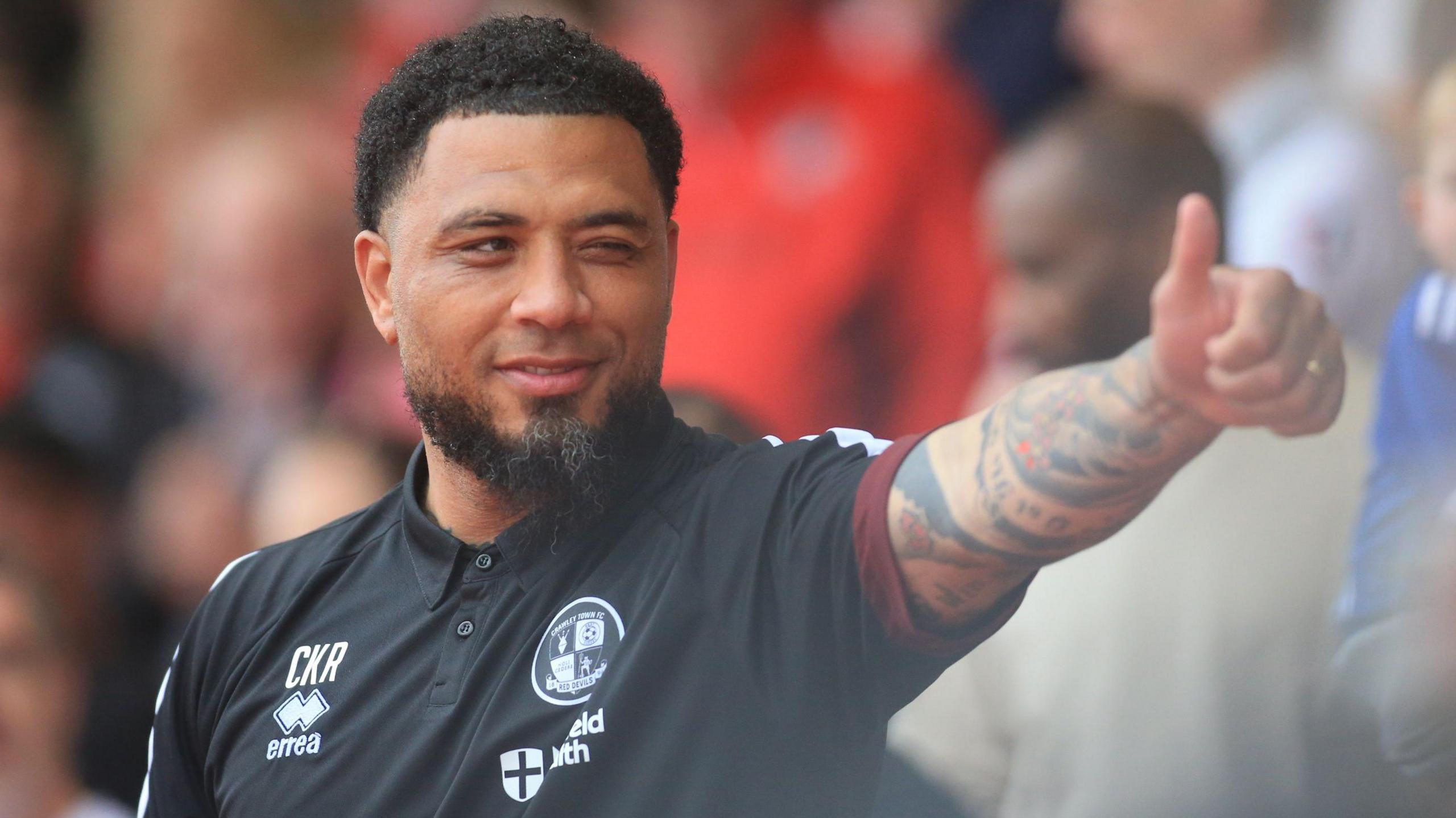 Colin Kazim-Richards holds a thumbs-up and winks at a supporter