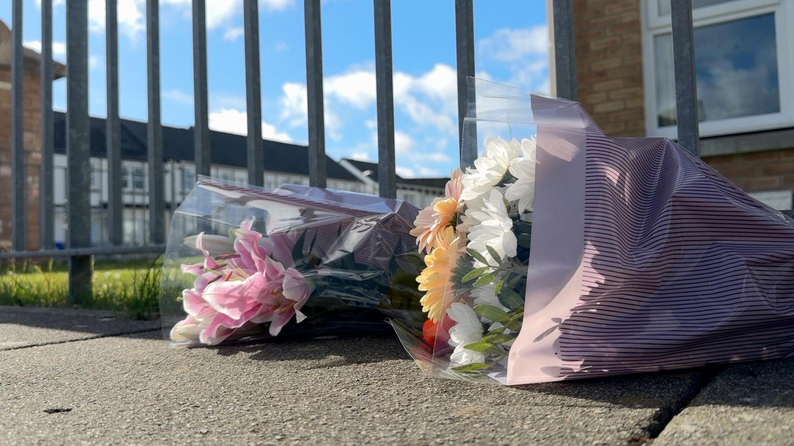 Two bouquets of flowers on the pavement
