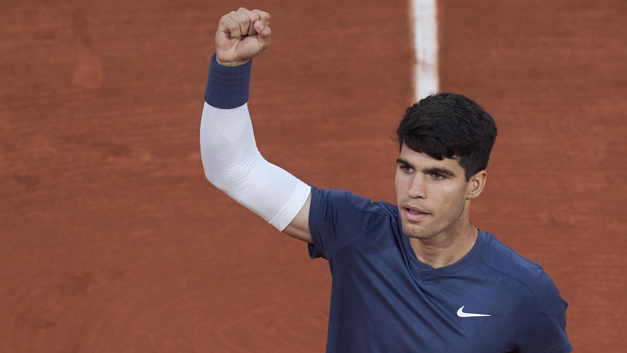 Carlos Alcaraz raises his fist in celebration at the 2024 French Open