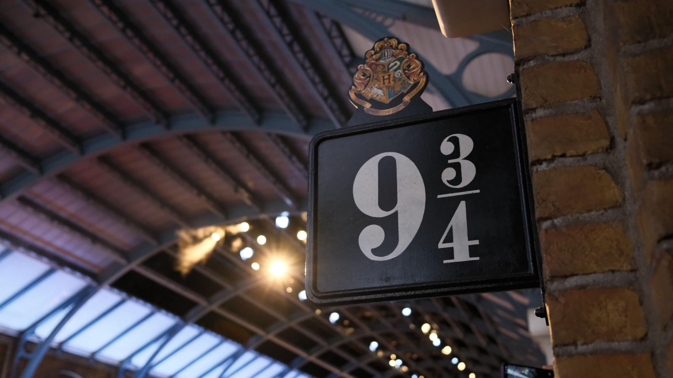 A sign that reads nine-and-three-quarters in a train station.
