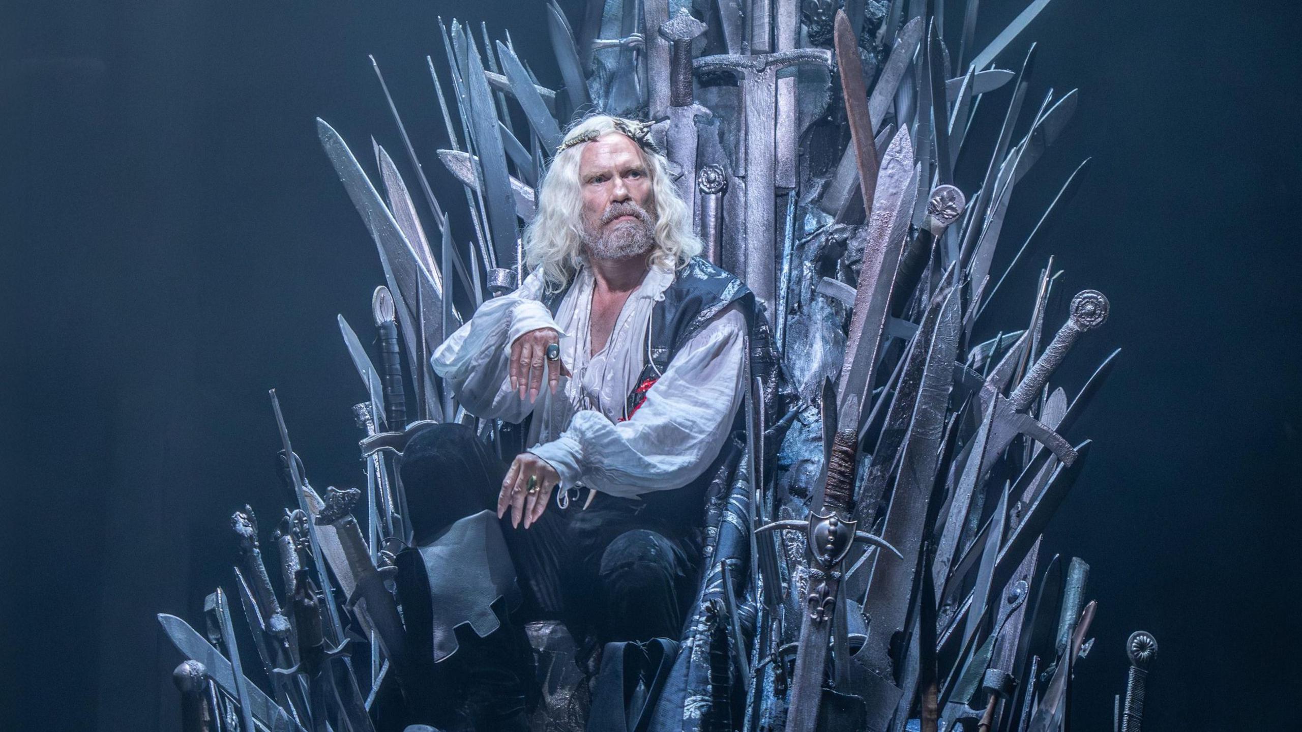 Michael Shaeffer (King Aerys II Targaryen) seated on the Iron Throne, made from dozens of protruding swords, in a scene from Game of Thrones: The Mad King.