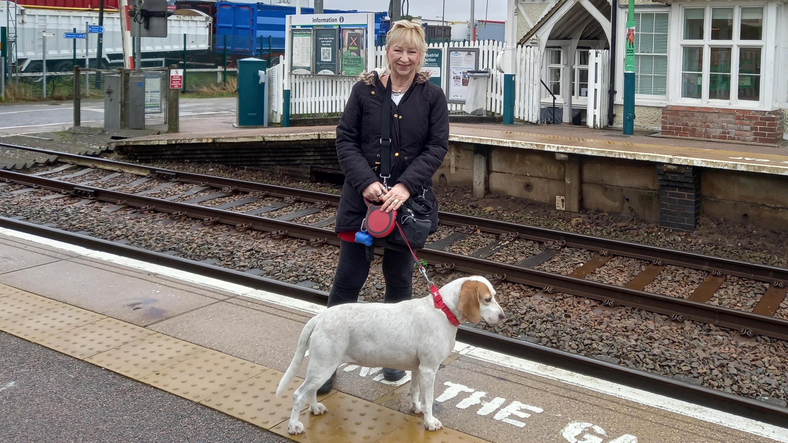 Tracy Carter and a dog at a railway station in Bedfordshire 