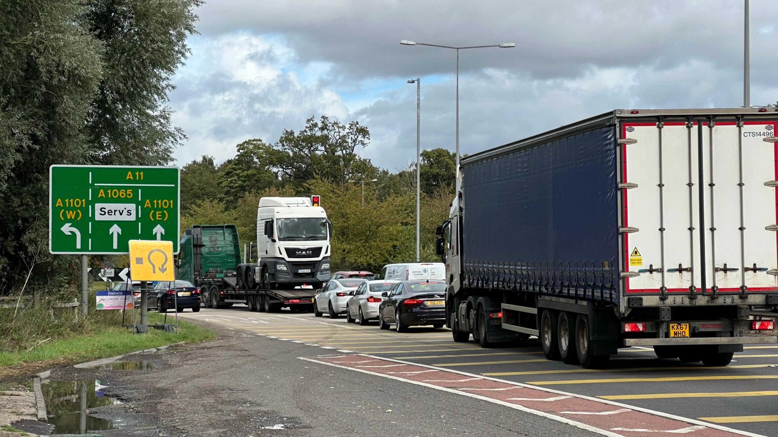 A general view of Barton Mills roundabout in Suffolk. It shows vehicles on approach to the roundabout. A road sign can be seen offering directions drivers can take around the roundabout. 