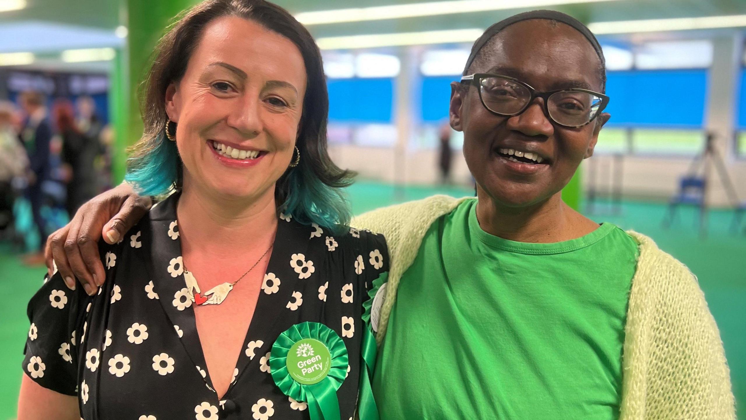 Emma Edwards, a Bristol green party councillor, with Lorraine Francis, both having been recently elected, look into the camera whilst smiling. 