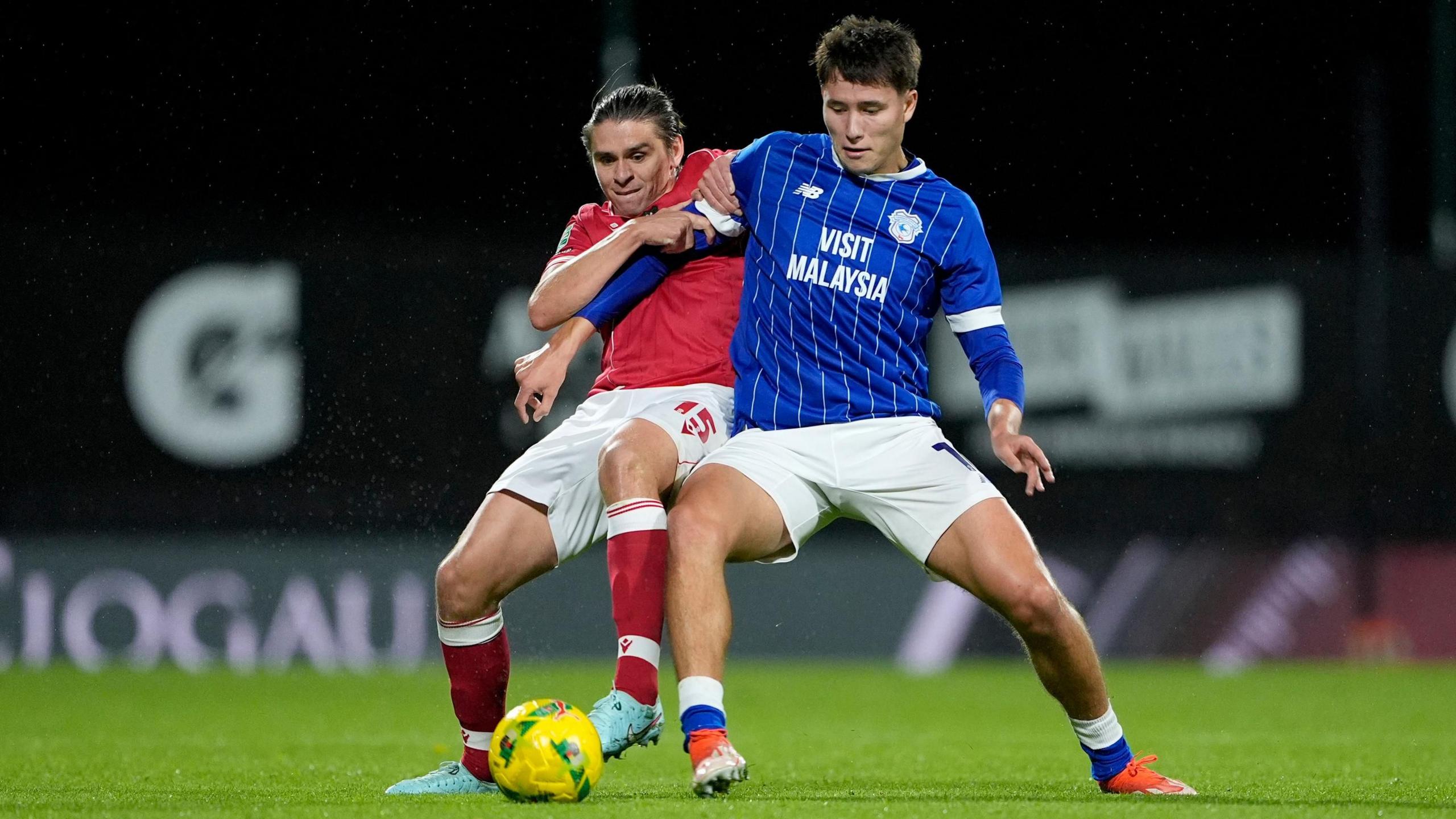 Wrexham's George Dobson and Cardiff City's Rubin Colwill battle for the ball.