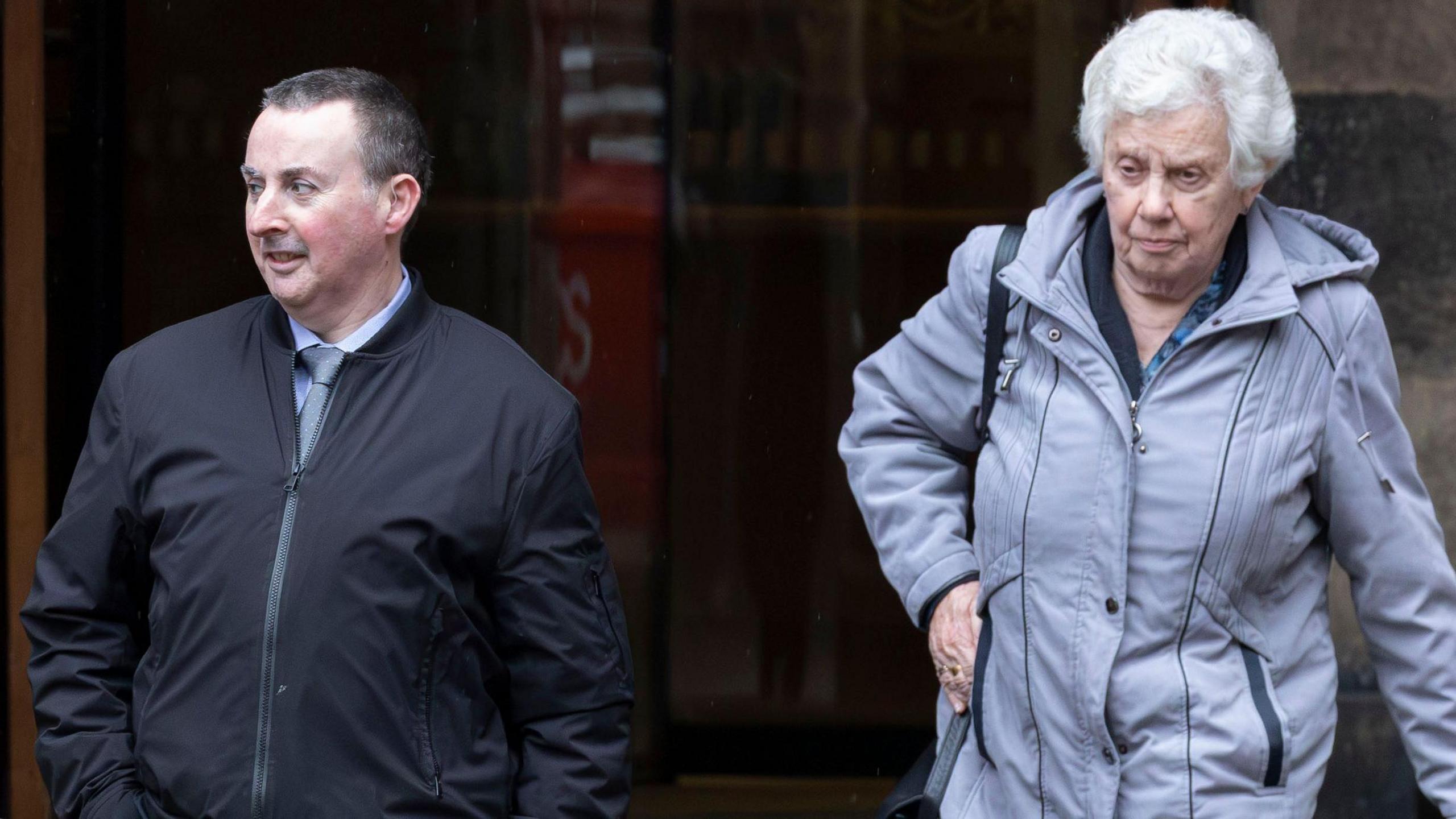 Steven and Jennifer Robertson outside the High Court in Edinburgh. He is wearing a blue jacket, light blue shirt and light blue patterned tie 
