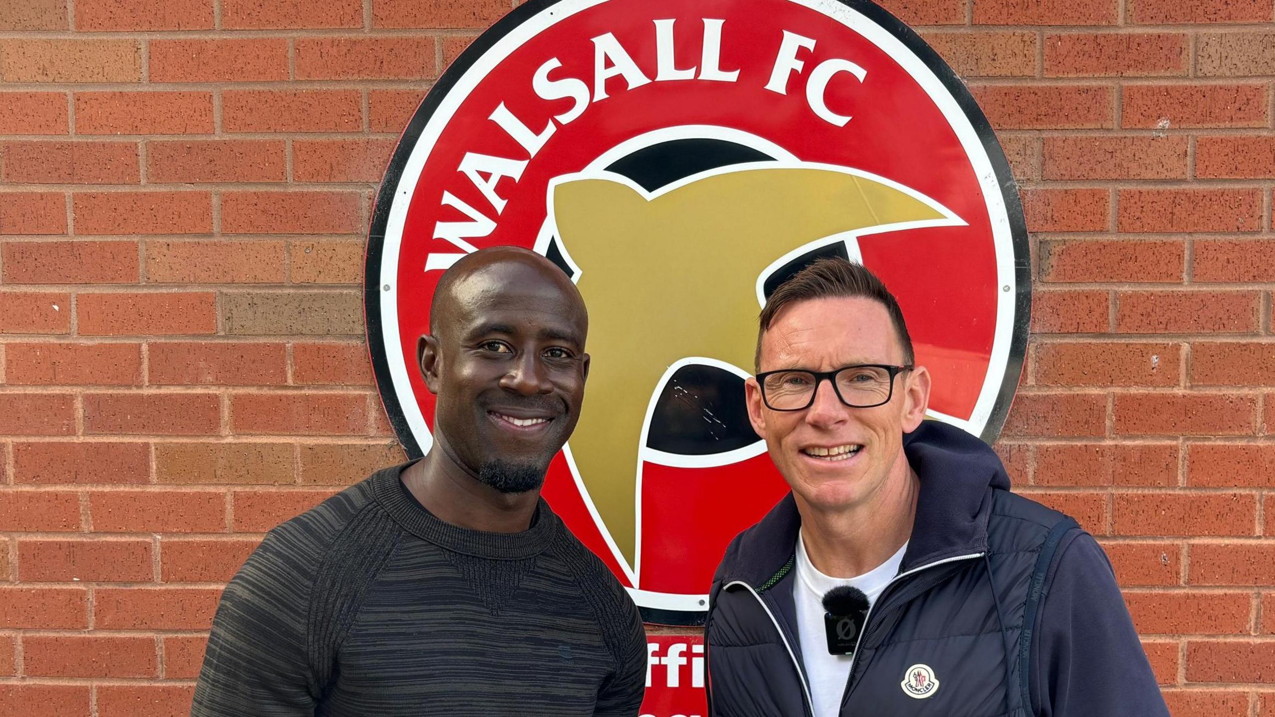Albert Adomah and BBC WM's Darren Wrack standing in front of the Walsall FC sign at their Essington training ground