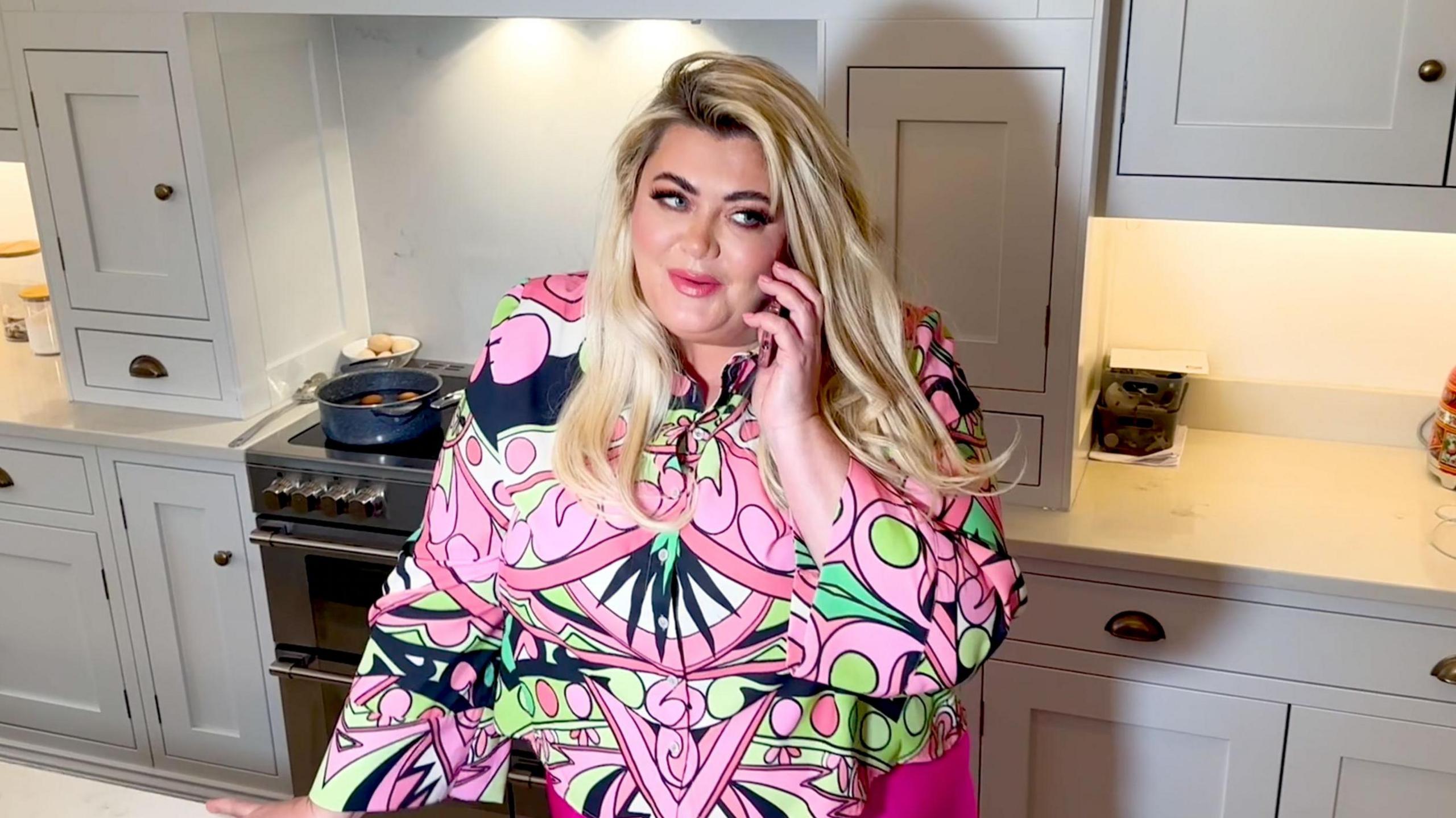 Gemma Collins on the phone in a kitchen