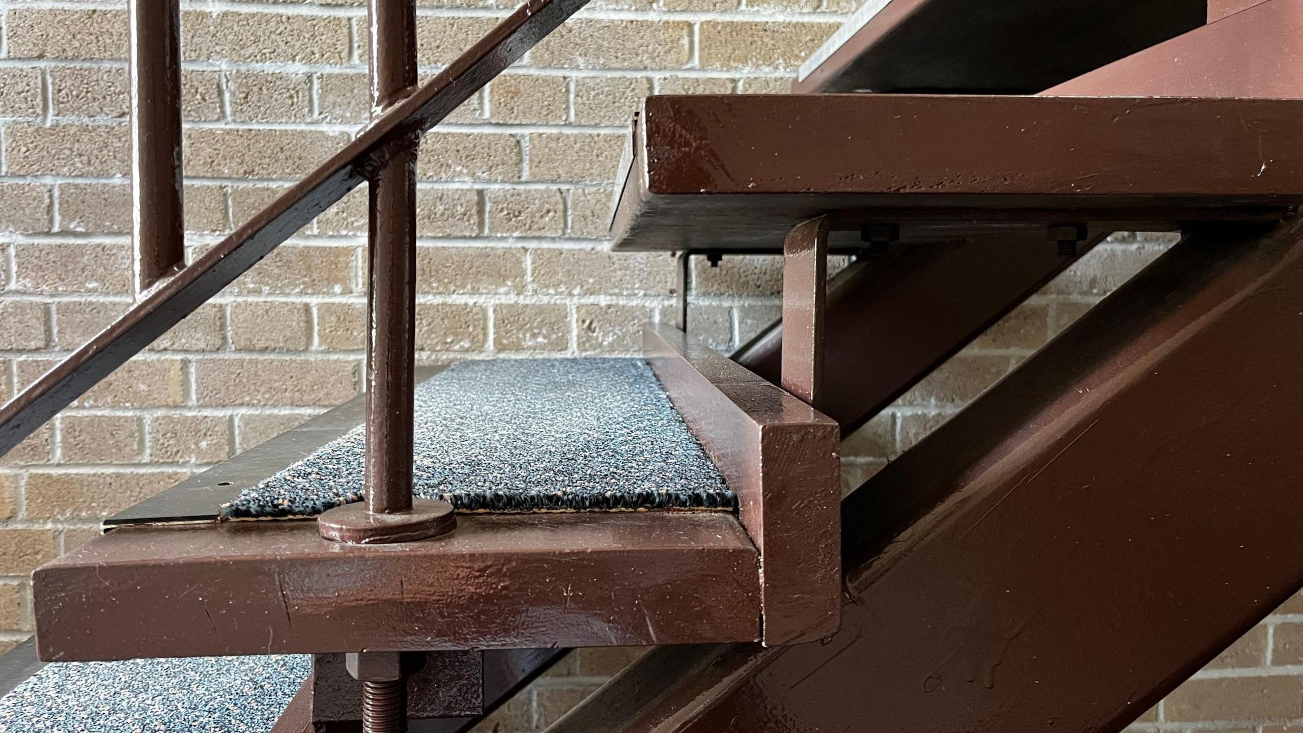 The image shows the side view of stairs that are in this block of flat. These stairs are open stairs so each step is a platform with space between each one. 