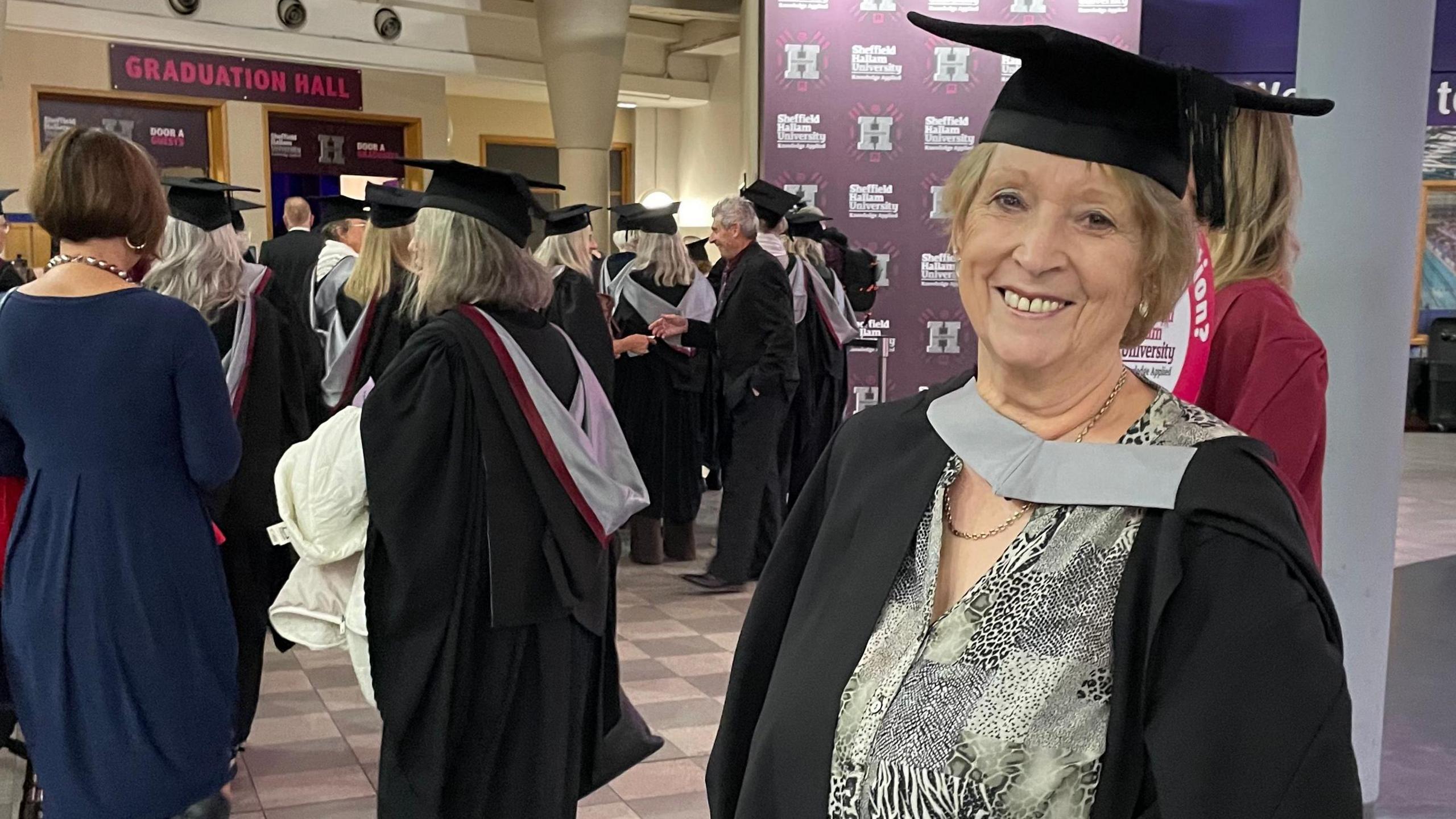 Janice Hopson stood in her own cap and gown.