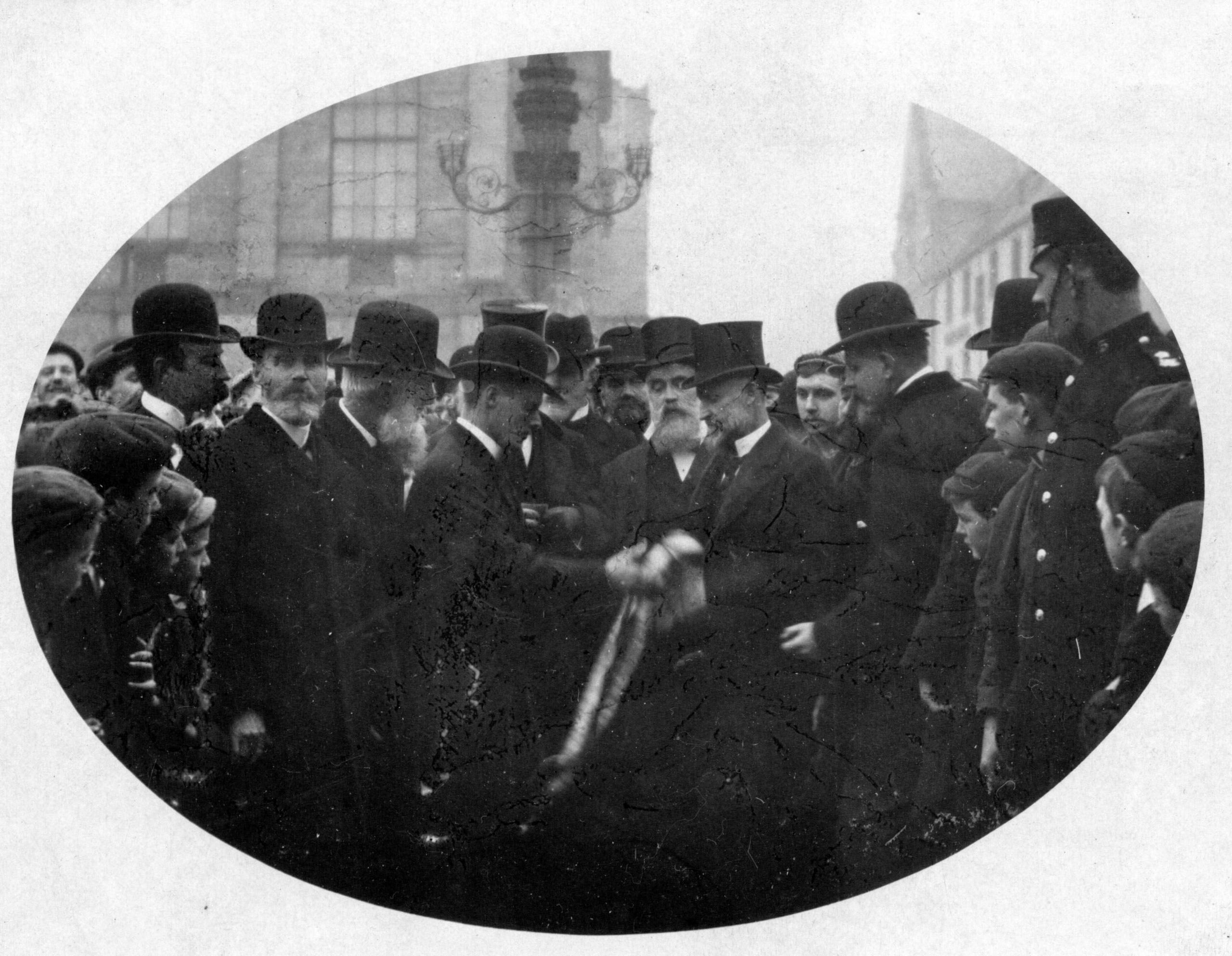 A black and white image of a handball game from years gone by with lots of men in bowler or top hats