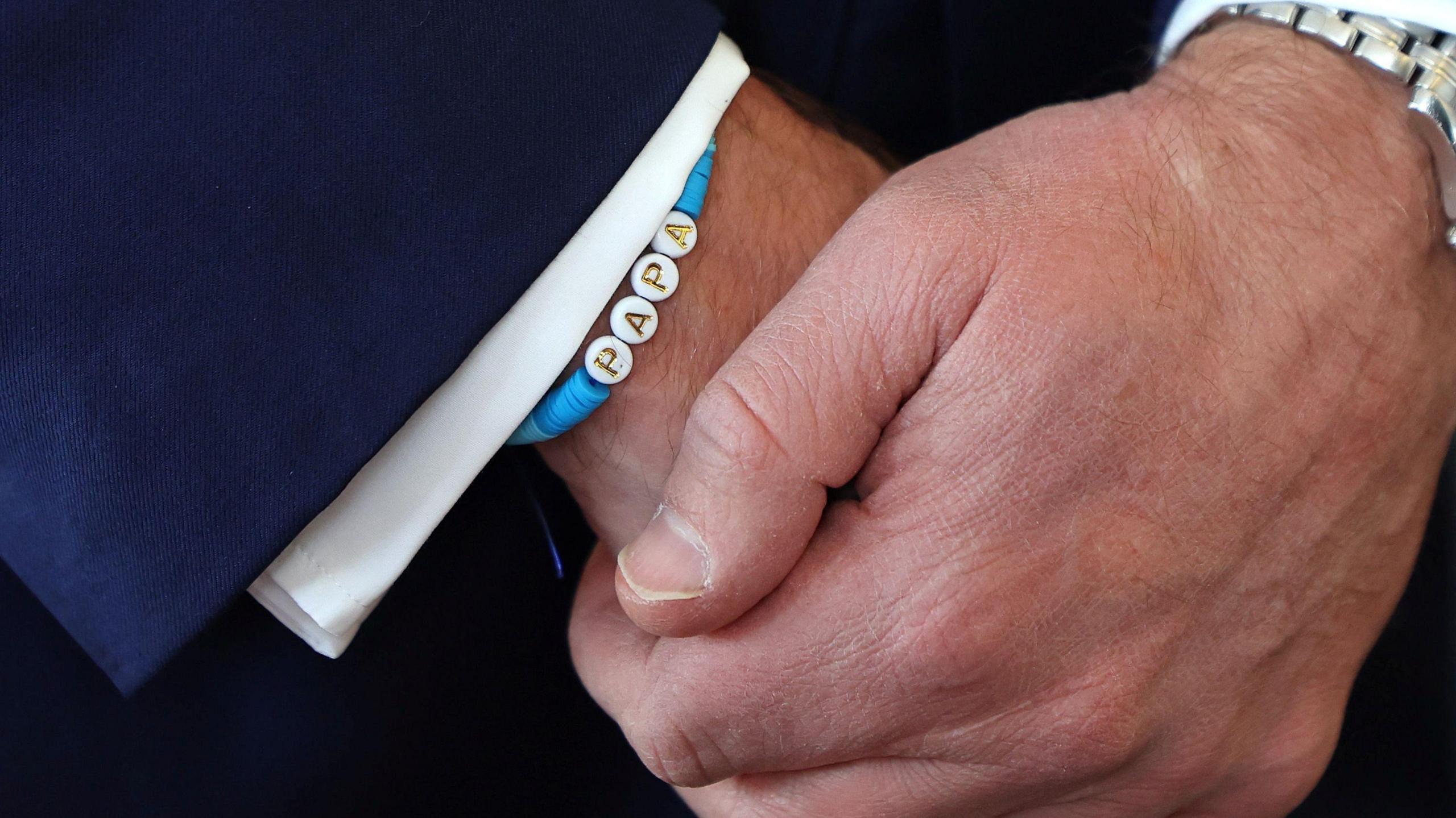 A close-up shot of Prince William's bracelet, which spells out "papa". 