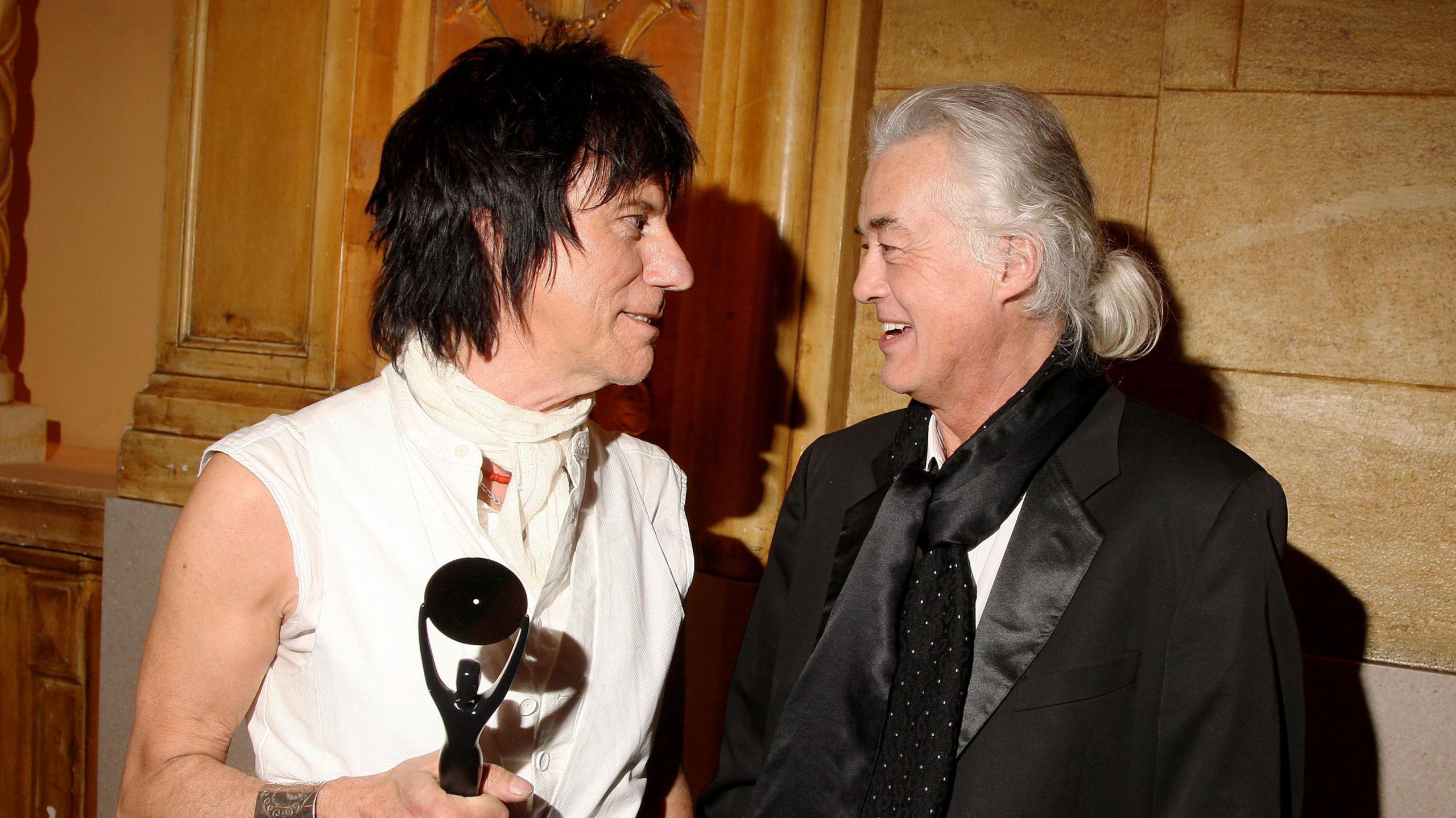 Jeff Beck and Jimmy Page pose at the 24th Annual Rock and Roll Hall of Fame Induction Ceremony at Public Hall on April 4, 2009 in Cleveland, Ohio. Jeff Beck, wears a white shirt and holds a statuette, while Jimmy Page wears a white shirt, black dinner jacket and black scarf.