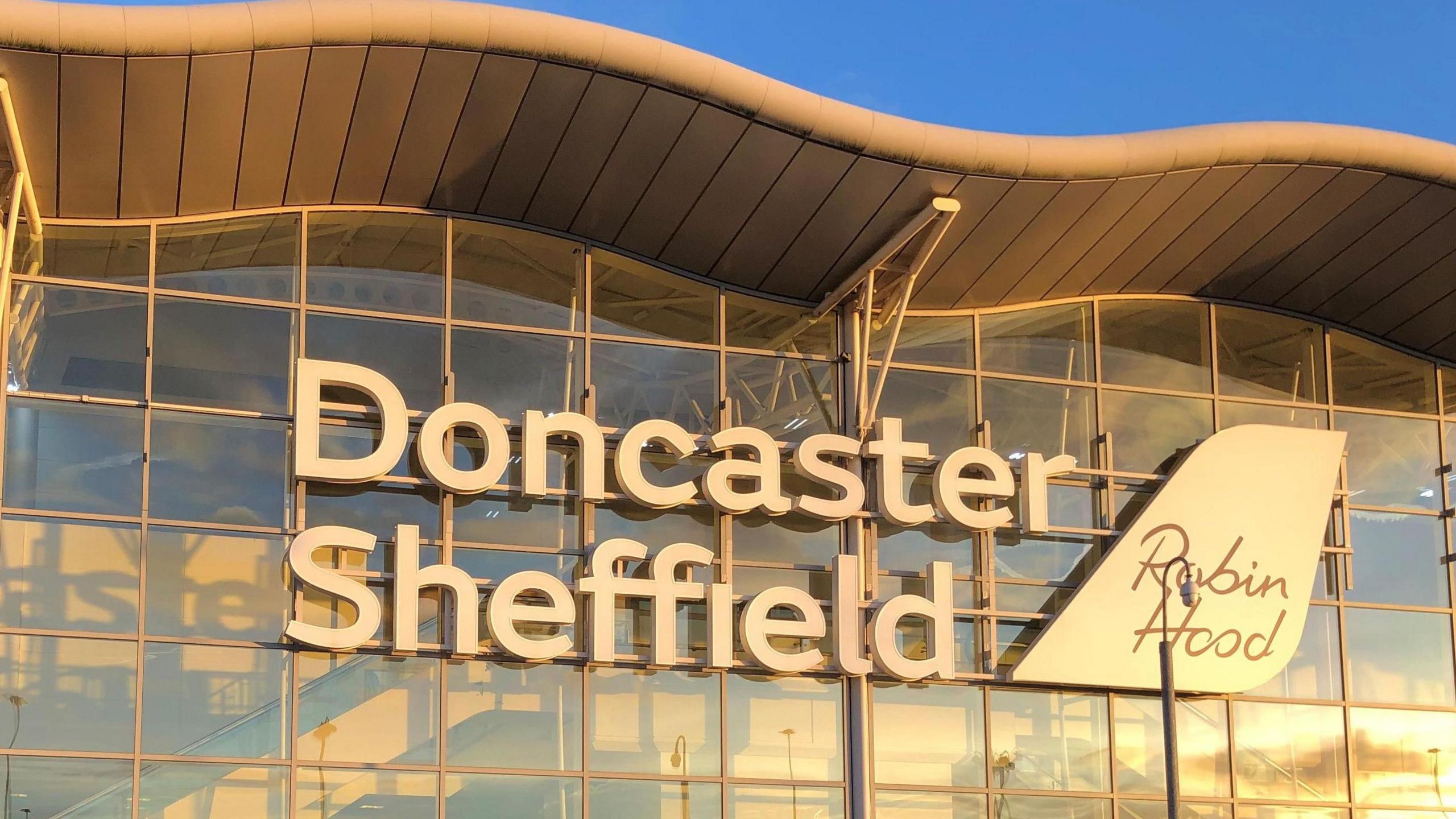 A sign on a glass building which reads Doncaster Sheffield Robin Hood