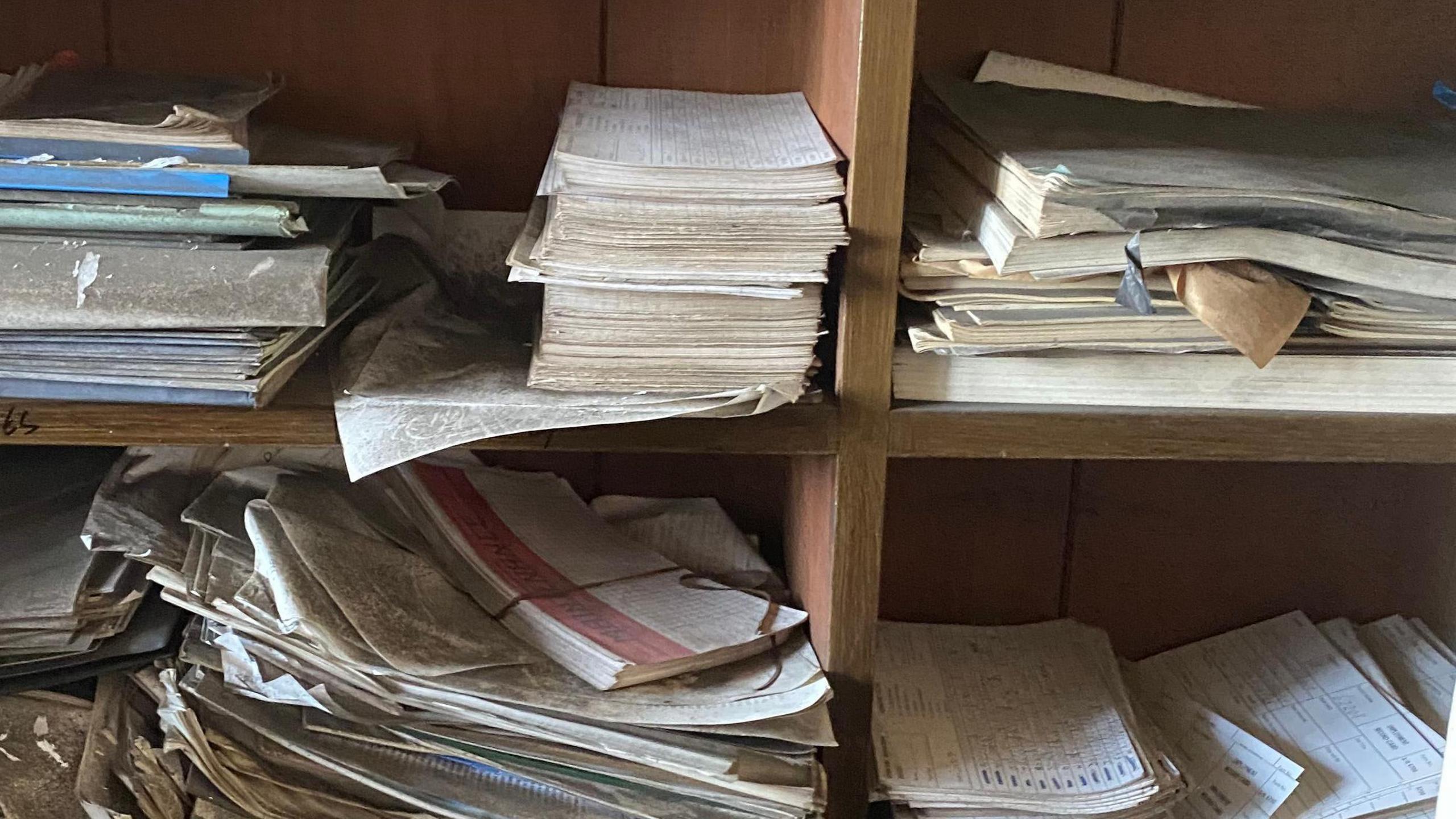 Piles of paperwork on a shelving unit