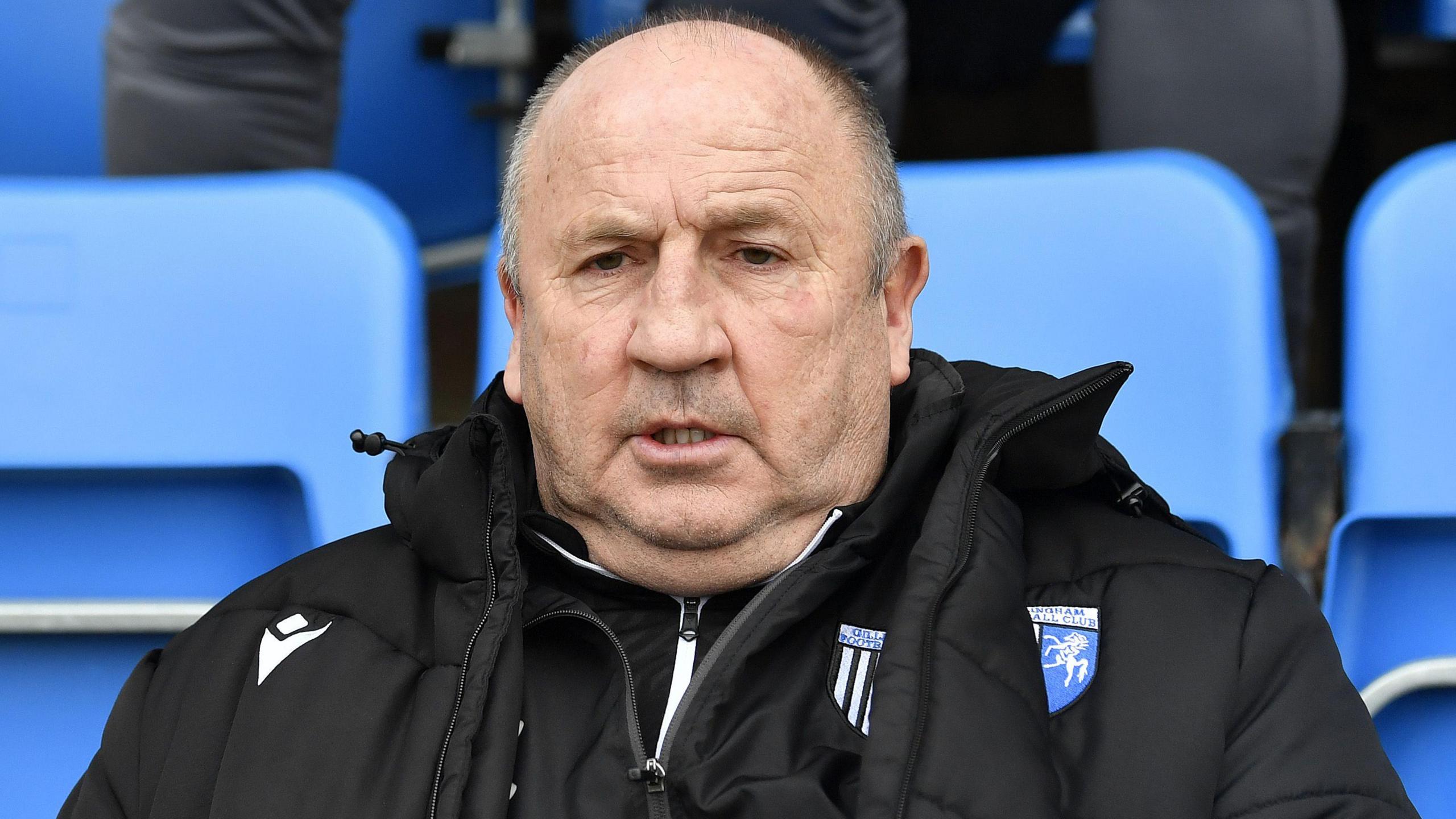 Gillingham boss John Coleman looks on sat in the technical area.