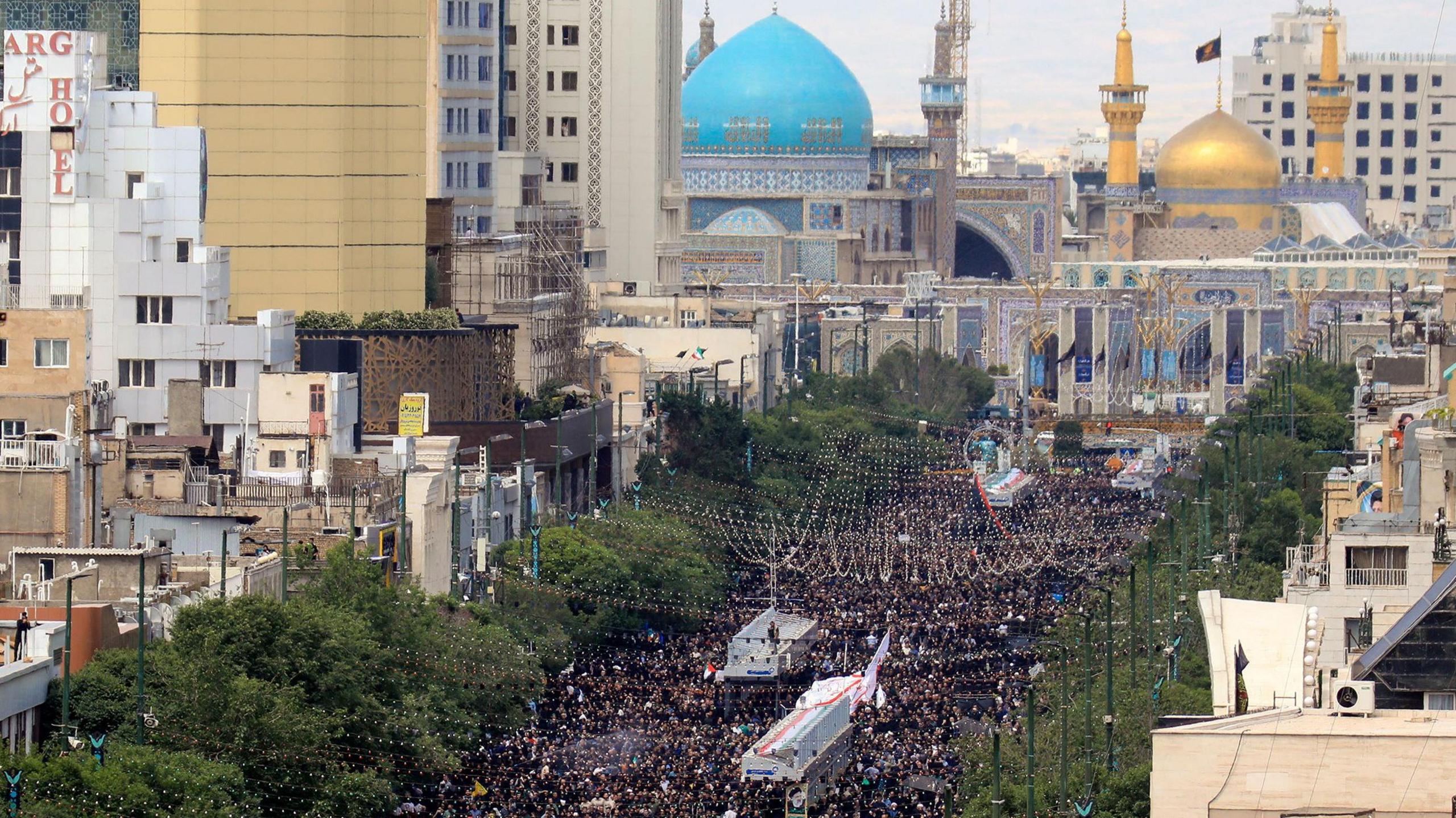 Mourners gather on a street in Mashhad, north-eastern Iran, for the burial of late president Ebrahim Raisi (23 May 2024)