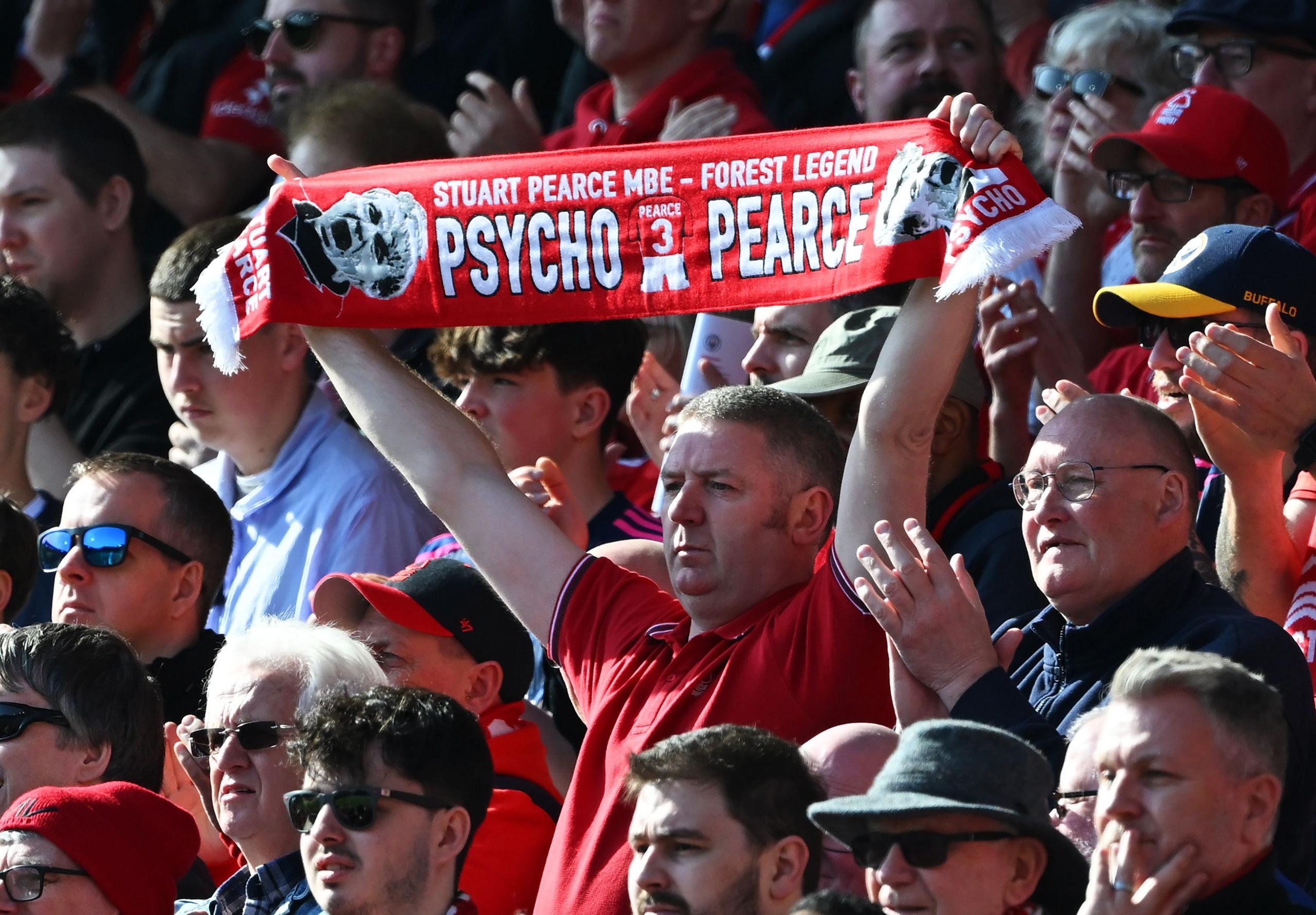 Nottingham Forest fan holds up a scarf which reads "Stuart Pearce MBE - Forest Legend" and "Pyscho Pearce", after former Manchester City and Nottingham Forest player Stuart Pearce was taken ill on a flight in the week prior to the game between Nottingham Forest FC and Manchester City at the City Ground 