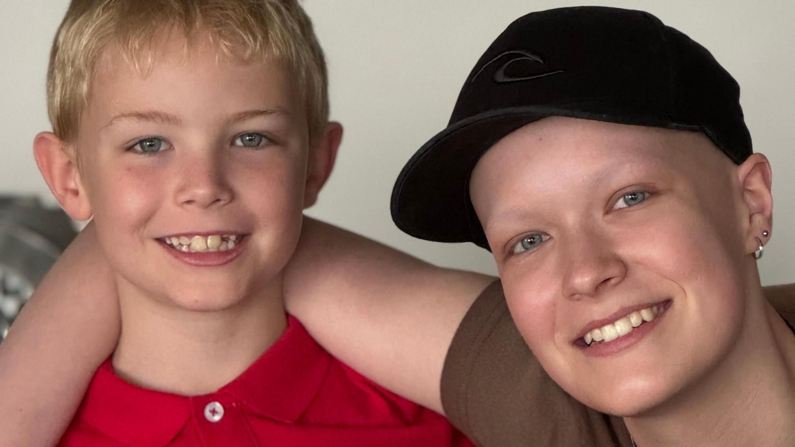 Liz Hatton, wearing a black cap, puts her arm around her brother Mateo.