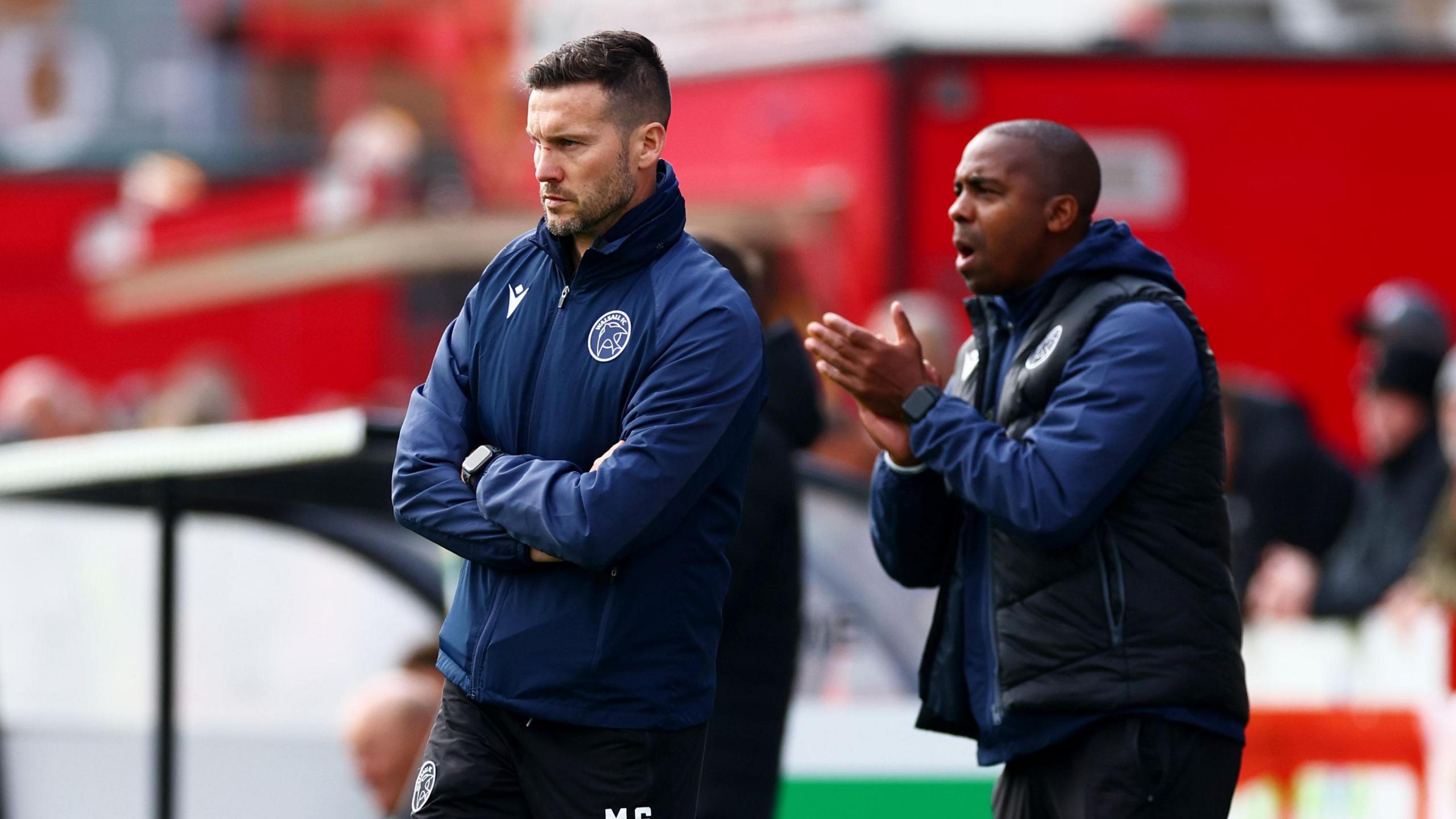 Mat Sadler and Darren Byfield encourage Walsall's players from the touchline