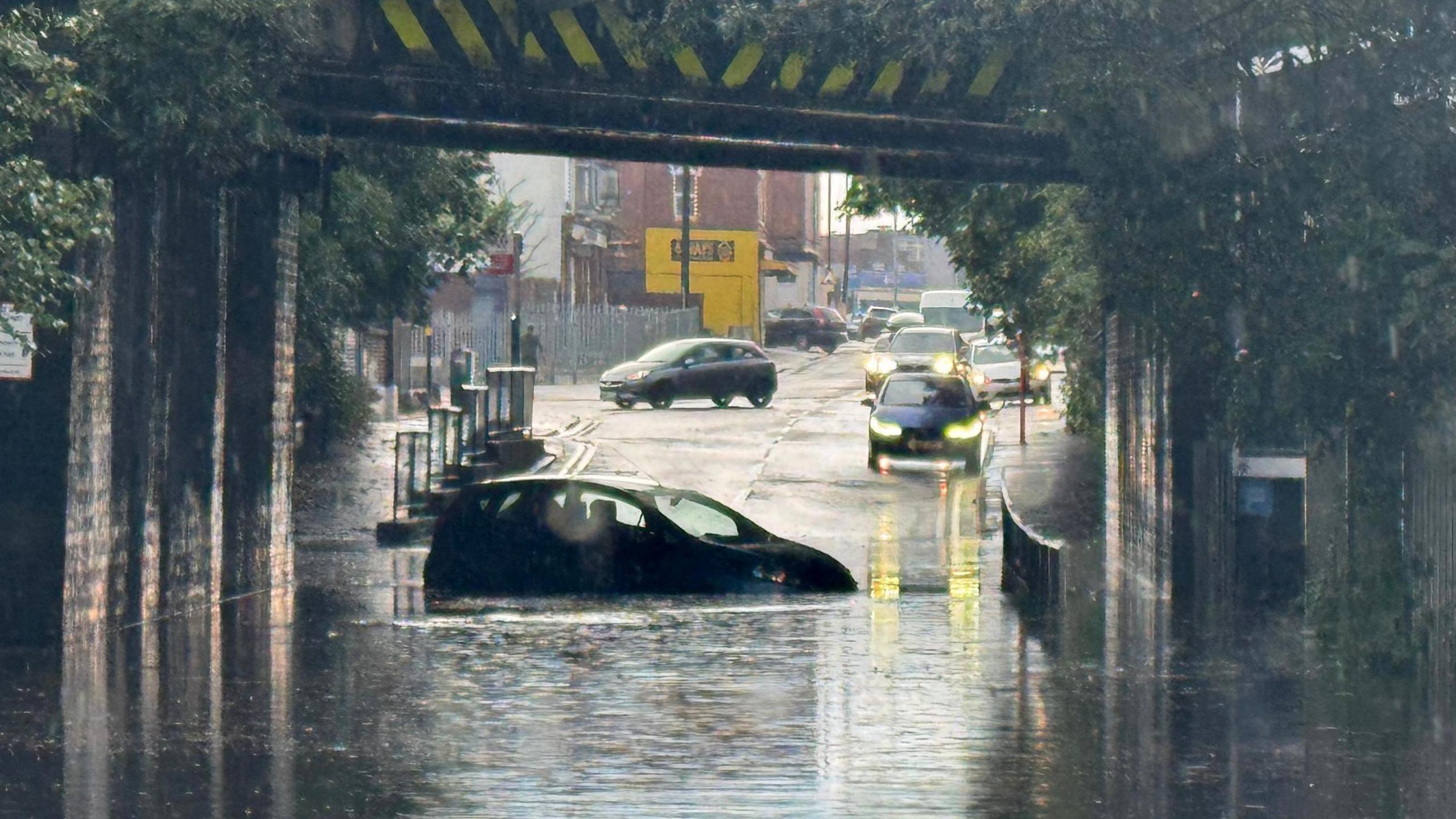 An abandoned car in floodwaters under a railway bridge in Erdington, Birmingham on 21 September.